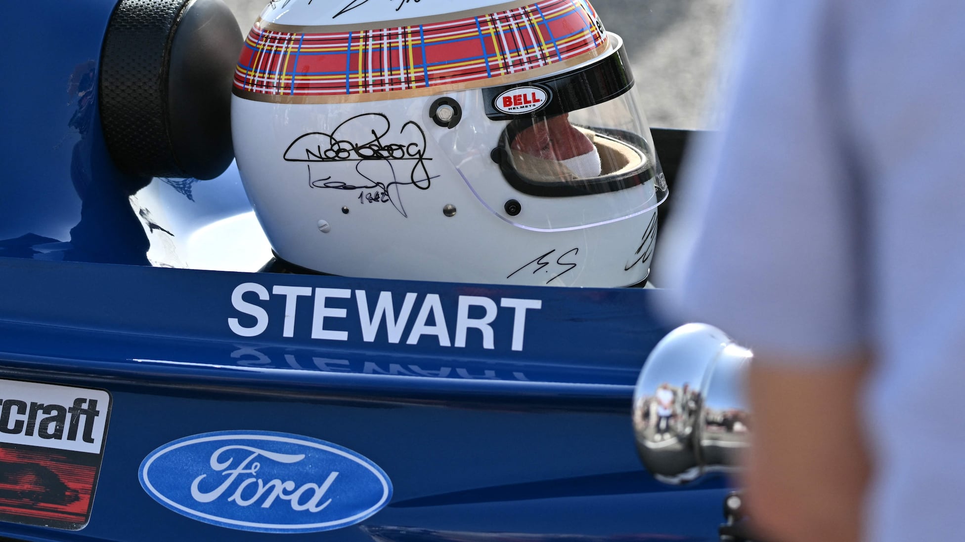 Schumacher firma en el casco de los campeones que llevó Stewart
